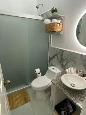 a bathroom with a white toilet and a sink at Golden Glow Getaway in San Miguel