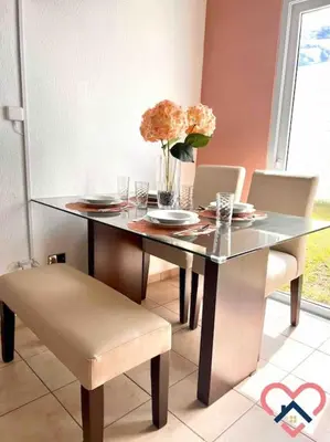 a dining room table with a vase of flowers on it at Acogedora Residencia Santaneca in Santa Ana