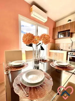 a kitchen with a table with plates and flowers on it at Acogedora Residencia Santaneca in Santa Ana
