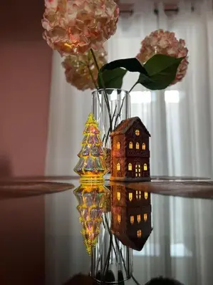 a vase with a house and flowers on a table at Acogedora Residencia Santaneca in Santa Ana