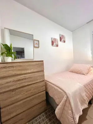 a bedroom with a bed with a dresser and a mirror at Acogedora Residencia Santaneca in Santa Ana