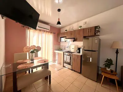 a kitchen with a table and a stainless steel refrigerator at Acogedora Residencia Santaneca in Santa Ana