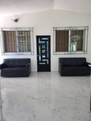 a room with two black couches and a door at Beach house playa san diego in La Libertad