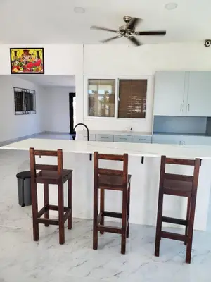 a kitchen with two chairs and a white counter top at Beach house playa san diego in La Libertad