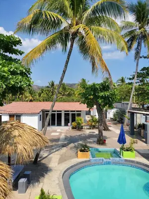 a villa with a swimming pool and palm trees at Beach house playa san diego in La Libertad
