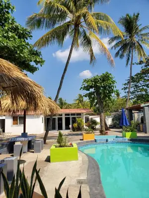 a resort pool with palm trees in the background at Beach house in la libertad in La Libertad