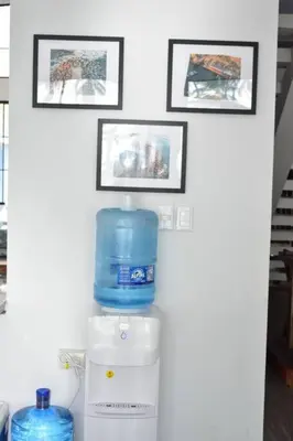 a white wall with three pictures and a water cooler at Rancho Plèyades in Metalío