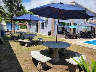 a table and benches with an umbrella next to a pool at Rancho Plèyades in Metalío