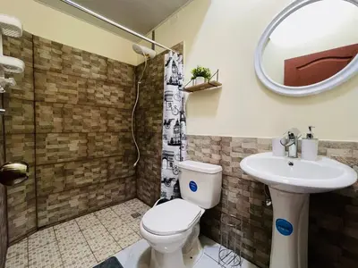 a bathroom with a toilet and a sink and a shower at Bambú Family House, AC, WiFi, near Metrocentro Mall in Santa Ana