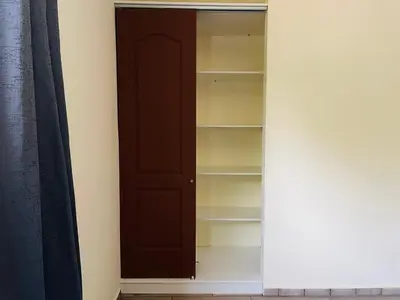 a closet with a dark brown door and shelves at Bambú Family House, AC, WiFi, near Metrocentro Mall in Santa Ana