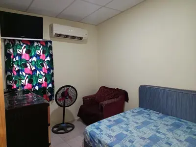 a bedroom with a bed and a chair and a fan at Hostal Paradise blue in La Libertad