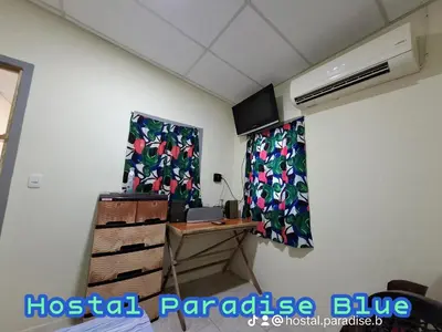a room with two curtains and a desk with a fan at Hostal Paradise blue in La Libertad