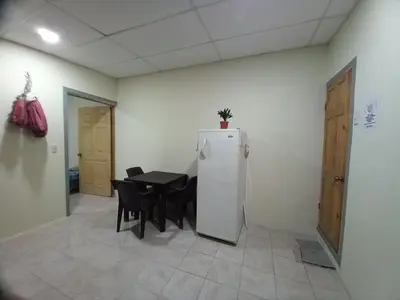 a dining room with a table and a refrigerator at Hostal Paradise blue in La Libertad