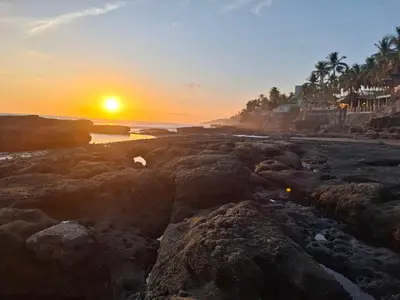a sunset on a rocky beach with the ocean at Hostal Paradise blue in La Libertad