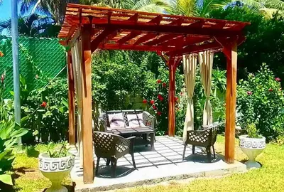 a wooden gazebo with chairs and a bench at Casa De Playa Atlantis in San Luis