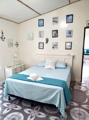 a bedroom with a bed and pictures on the wall at Casa De Playa Atlantis in San Luis