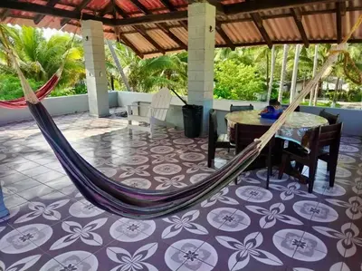 a hammock on a patio with a table and chairs at Casa De Playa Atlantis in San Luis