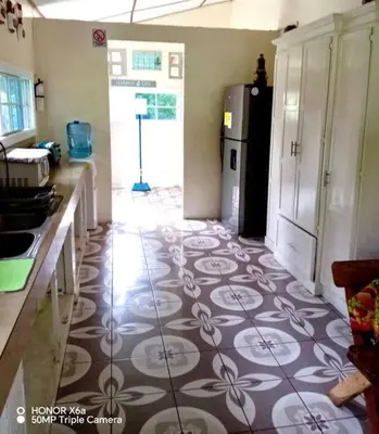 a kitchen with a tile floor with a refrigerator at Casa De Playa Atlantis in San Luis
