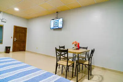 a bedroom with a table and chairs with a tv on the wall at Hotel Five Stars sv in Berlín