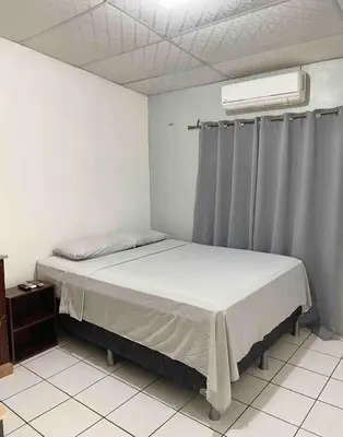 a bedroom with a bed and a window with curtains at Casa Familiar in San Miguel