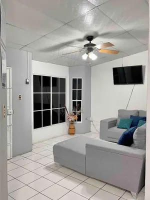 a living room with a couch and a ceiling fan at Casa Familiar in San Miguel