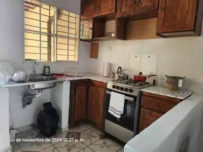 a kitchen with wooden cabinets and a stove top oven at Casa las Flores in San Miguel