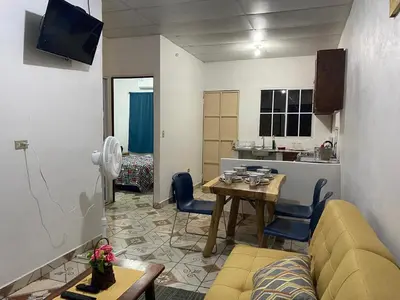 a living room with a couch and a table and a kitchen at Casa las Flores in San Miguel