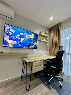 a room with a desk and a monitor on the wall at Cool Spot By Rooftop Masferrer in San Salvador