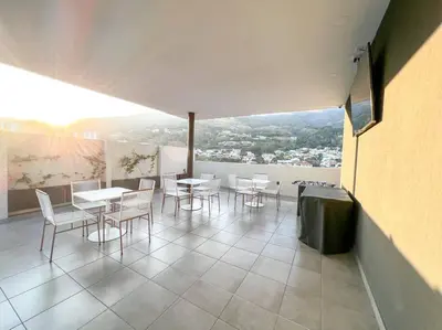 a dining room with tables and chairs on a balcony at Upper Scale and Cozy Apart in the Heart of Escalon in San Salvador
