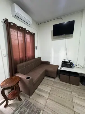 a living room with a couch and a tv at Emmitas room in La Unión