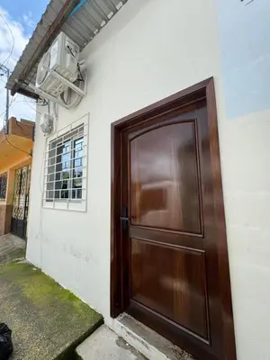 a brown door on the side of a house at Emmitas room in La Unión