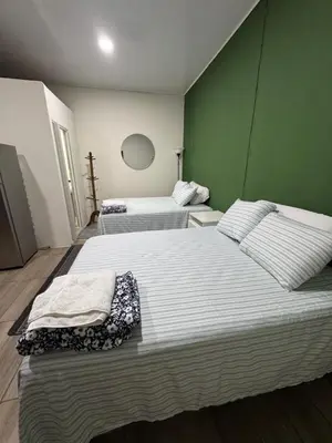 two beds in a room with green walls at Emmitas room in La Unión