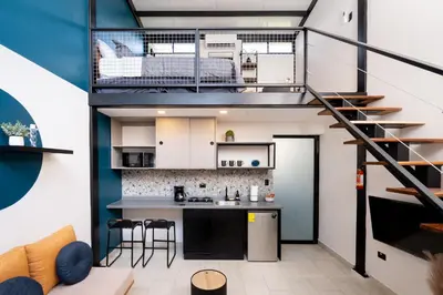 a loft apartment with a kitchen and a staircase at Quaranta Lofts in Antiguo Cuscatlán