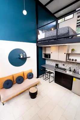 a living room with a couch and a kitchen at Quaranta Lofts in Antiguo Cuscatlán