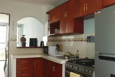 a kitchen with wooden cabinets and a stove top oven at casa en la Cima in San Salvador