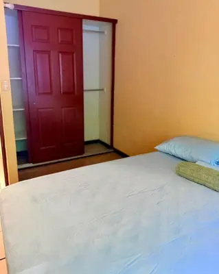 a bedroom with a bed and a red door at casa en la Cima in San Salvador