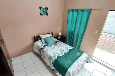 a bedroom with a bed with a green curtain at Marron House's Arizona 2 in Santa Ana