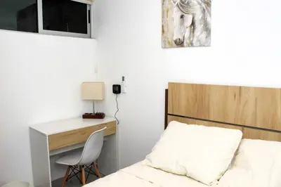 a bedroom with a bed with a desk and a horse picture at Amazing City Views, with Queen Bed and Pool in San Salvador