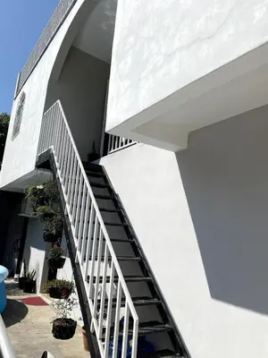 a staircase leading up to a white building with potted plants at Habitación cerca del aeropuerto #3 in La Paz