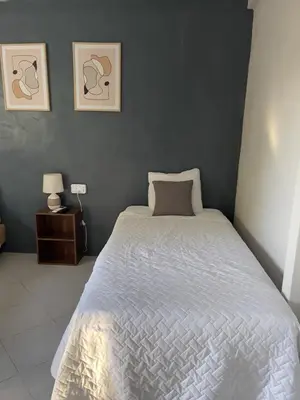 a bedroom with a bed with a white comforter at Habitación cerca del aeropuerto #3 in La Paz
