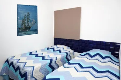 a bedroom with a bed and a picture on the wall at La Petite Santa Ana in Santa Ana