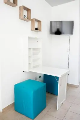a white desk with a blue stool in a room at La Petite Santa Ana in Santa Ana