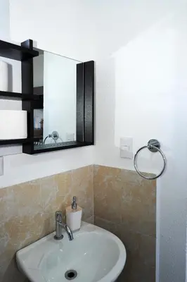 a bathroom with a sink and a mirror at La Petite Santa Ana in Santa Ana