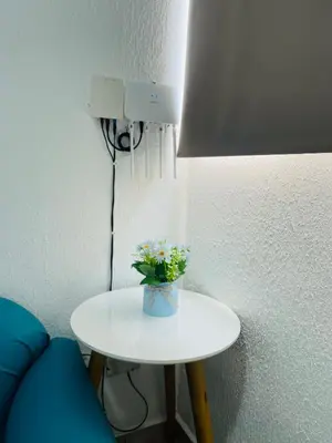 a white table with a vase of flowers on it at La Petite Santa Ana in Santa Ana
