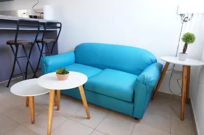a blue couch and two tables in a room at La Petite Santa Ana in Santa Ana