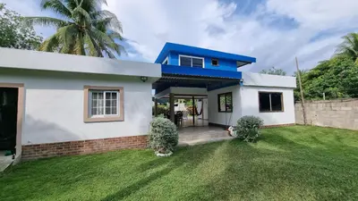 a small white house with a blue roof at Casa con Piscina y Rancho, cerca de Estero y Playa in El Zapote