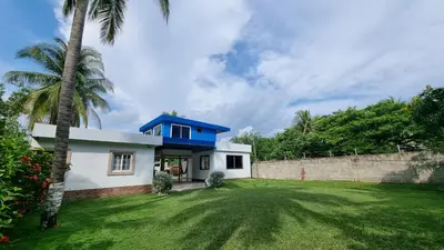 a house with a blue roof and a yard at Casa con Piscina y Rancho, cerca de Estero y Playa in El Zapote