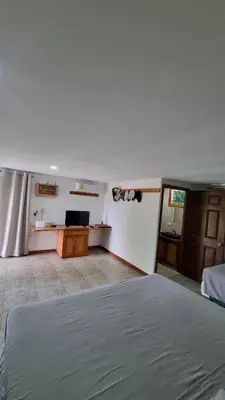 a bedroom with a bed and a television in it at Casa con Piscina y Rancho, cerca de Estero y Playa in El Zapote