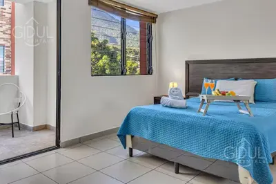 a bedroom with a bed with a tray of fruit on it at San Salvador Mountain & City Views Apartment in San Salvador