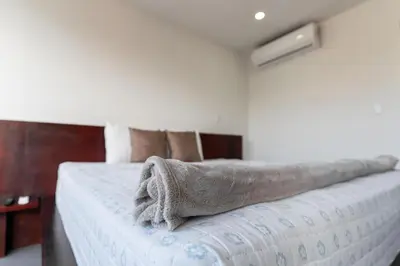 a bedroom with a bed with a blanket on it at Luxury apartment at Galerias in San Salvador
